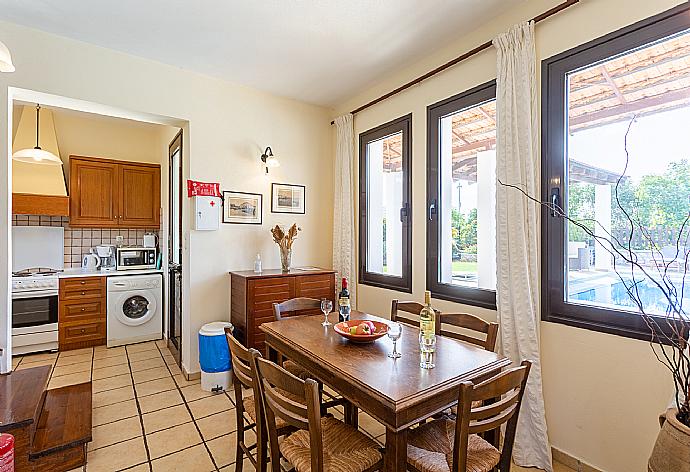 Living room with sofa, dining area, ornamental fireplace, WiFi internet, satellite TV, DVD player, and pool terrace access . - Villa Kefalas . (Galerie de photos) }}