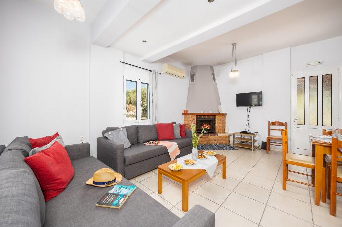 Open-plan living room with sofas, dining area, kitchen, ornamental fireplace, A/C, WiFi internet, and satellite TV . - Villa Dimitris . (Photo Gallery) }}