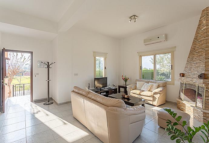 Open-plan living room with sofas, dining area, kitchen, ornamental fireplace, A/C, WiFi internet, satellite TV, DVD player, and terrace access . - Villa Prodromos . (Galería de imágenes) }}