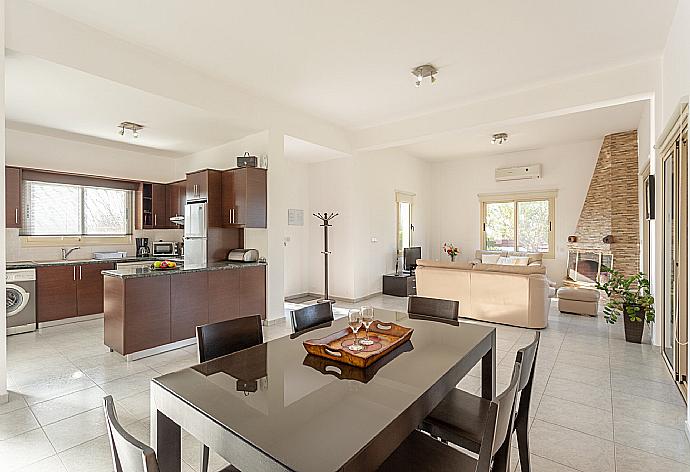 Open-plan living room with sofas, dining area, kitchen, ornamental fireplace, A/C, WiFi internet, satellite TV, DVD player, and terrace access . - Villa Prodromos . (Galería de imágenes) }}