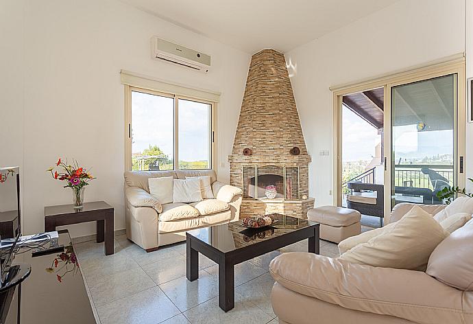 Open-plan living room with sofas, dining area, kitchen, ornamental fireplace, A/C, WiFi internet, satellite TV, DVD player, and terrace access . - Villa Prodromos . (Fotogalerie) }}