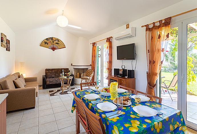 Open-plan living room with sofas, dining area, kitchen, ornamental fireplace, A/C, WiFi internet, satellite TV, and terrace access . - Villa Melissa . (Galleria fotografica) }}