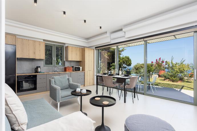 Open-plan living room with sofa, dining area, kitchen, A/C, WiFi internet, satellite TV, and sea views . - Villa Michalis . (Fotogalerie) }}