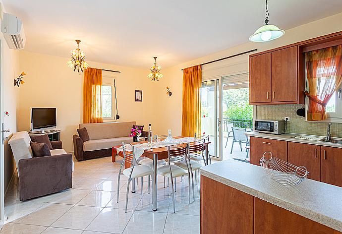 Open-plan living room with sofas, dining area, kitchen, A/C, WiFi internet, satellite TV, DVD player, and terrace access . - Villa Georgia . (Galería de imágenes) }}