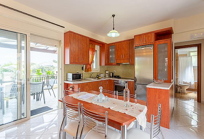 Open-plan living room with sofas, dining area, kitchen, A/C, WiFi internet, satellite TV, DVD player, and terrace access . - Villa Georgia . (Galería de imágenes) }}