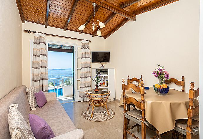 Living room with sofa, dining area, WiFi internet, TV, terrace access, and sea views  . - Villa Elia . (Galleria fotografica) }}