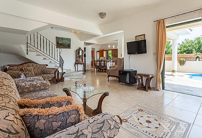 Open-plan living room with sofas, dining area, kitchen, ornamental fireplace, A/C, WiFi internet, satellite TV, and terrace access . - Villa Charianna . (Fotogalerie) }}