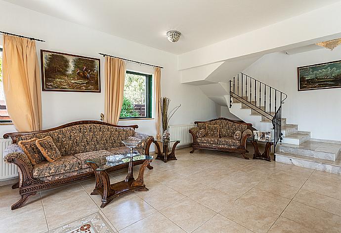 Open-plan living room with sofas, dining area, kitchen, ornamental fireplace, A/C, WiFi internet, satellite TV, and terrace access . - Villa Charianna . (Fotogalerie) }}