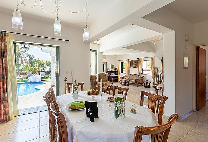 Open-plan living room with sofas, dining area, kitchen, ornamental fireplace, A/C, WiFi internet, satellite TV, and terrace access . - Villa Charianna . (Fotogalerie) }}