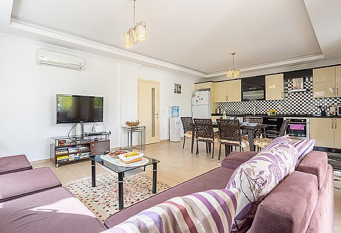 Open-plan living room with sofas, dining area, kitchen, A/C, WiFi internet, satellite TV, and terrace access . - Villa Canberk . (Fotogalerie) }}