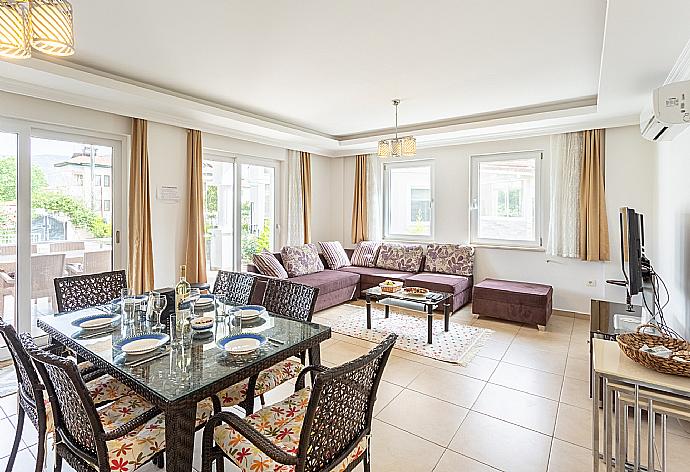 Open-plan living room with sofas, dining area, kitchen, A/C, WiFi internet, satellite TV, and terrace access . - Villa Canberk . (Fotogalerie) }}