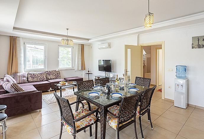 Open-plan living room with sofas, dining area, kitchen, A/C, WiFi internet, satellite TV, and terrace access . - Villa Canberk . (Galería de imágenes) }}