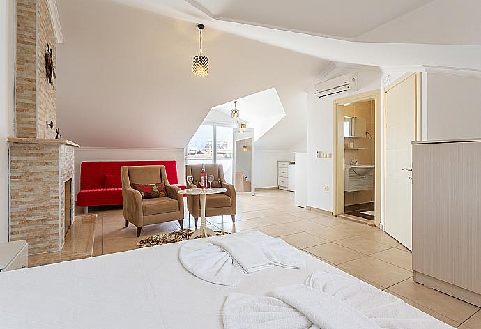 Double bedroom with en suite bathroom, A/C, seating, ornamental fireplace, and balcony access . - Villa Canberk . (Galería de imágenes) }}