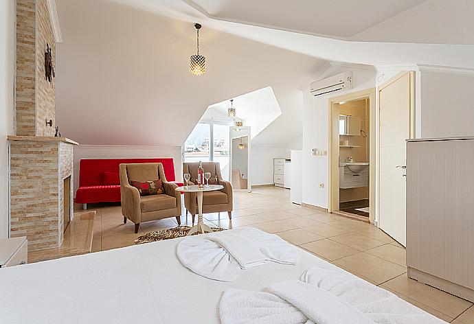 Double bedroom with en suite bathroom, A/C, seating, ornamental fireplace, and balcony access . - Villa Canberk . (Galleria fotografica) }}