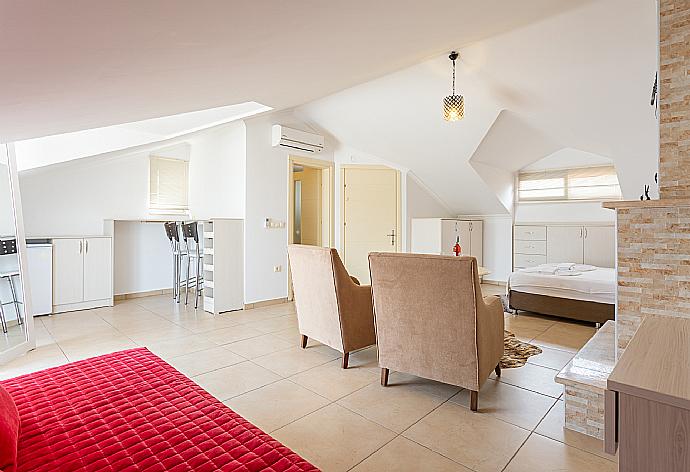 Double bedroom with en suite bathroom, A/C, seating, ornamental fireplace, and balcony access . - Villa Canberk . (Galleria fotografica) }}