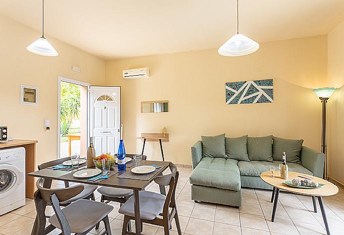 Open-plan living room with sofa, dining area, kitchen, A/C, WiFi internet, and satellite TV . - Villa Russa Alexandros . (Fotogalerie) }}