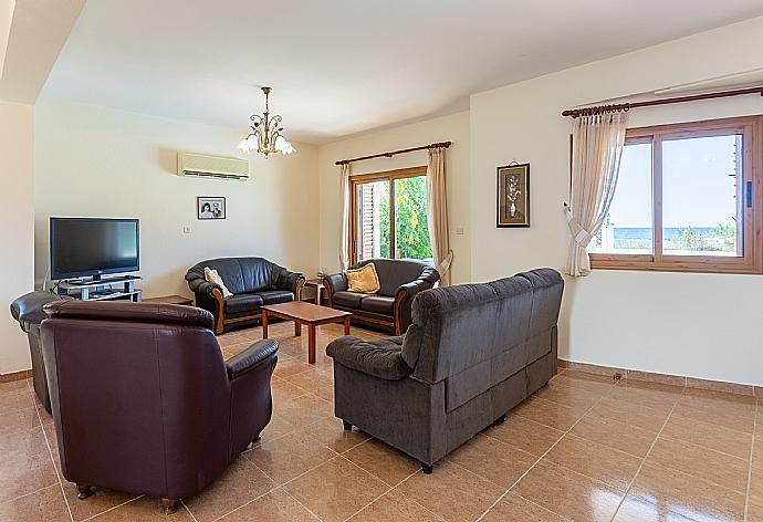 Open-plan living room with sofas, dining areas, kitchen, A/C, WiFi internet, satellite TV, and terrace access . - Achilles Beach Villa . (Fotogalerie) }}