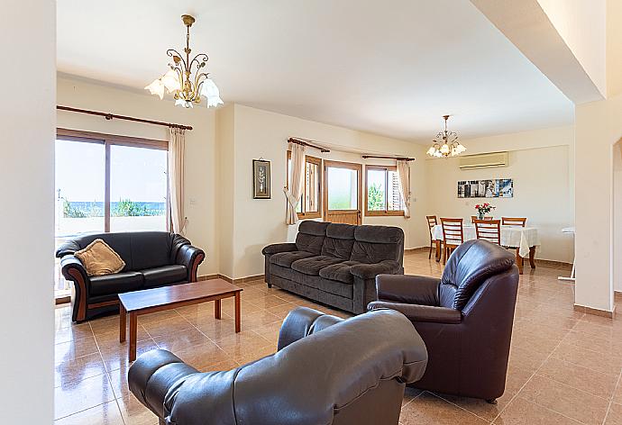 Open-plan living room with sofas, dining areas, kitchen, A/C, WiFi internet, satellite TV, and terrace access . - Achilles Beach Villa . (Galleria fotografica) }}