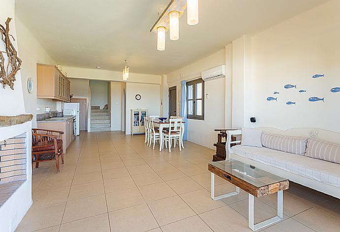 Open-plan living room with sofa, dining area, kitchen, ornamental fireplace, A/C, WiFi internet, satellite TV, and terrace access . - Villa Almira . (Fotogalerie) }}