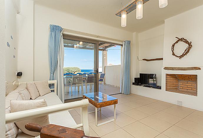 Open-plan living room with sofa, dining area, kitchen, ornamental fireplace, A/C, WiFi internet, satellite TV, and terrace access . - Villa Almira . (Fotogalerie) }}