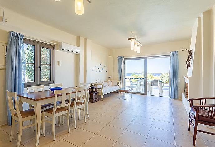 Open-plan living room with sofa, dining area, kitchen, ornamental fireplace, A/C, WiFi internet, satellite TV, and terrace access . - Villa Almira . (Galleria fotografica) }}