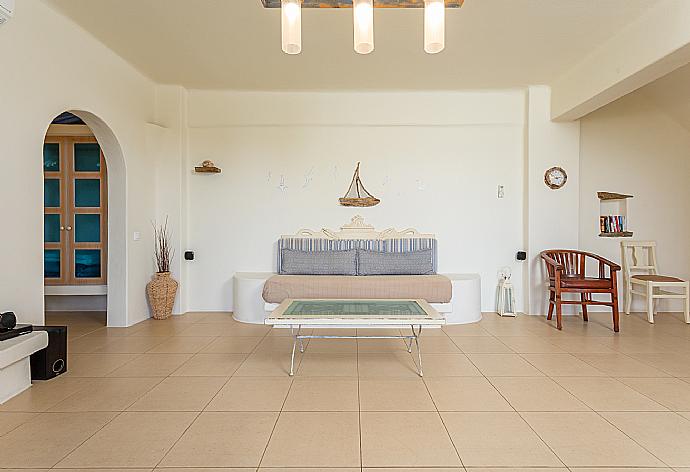 Open-plan living room with sofa, dining area, kitchen, ornamental fireplace, A/C, WiFi internet, satellite TV, DVD player, and terrace access . - Villa Liakada . (Fotogalerie) }}