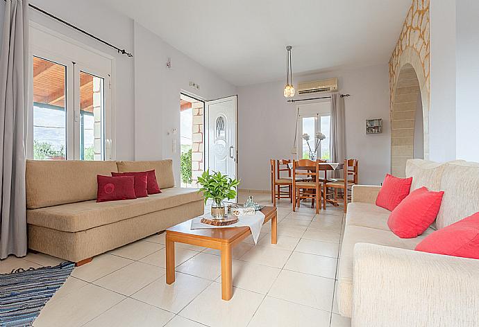 Open-plan living room with sofas, dining area, kitchen, ornamental fireplace, A/C, WiFi internet, TV, DVD player, and terrace access . - Villa Giannis . (Fotogalerie) }}