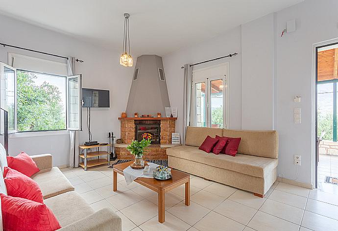 Open-plan living room with sofas, dining area, kitchen, ornamental fireplace, A/C, WiFi internet, TV, DVD player, and terrace access . - Villa Giannis . (Fotogalerie) }}