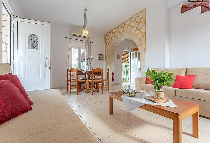 Open-plan living room with sofas, dining area, kitchen, ornamental fireplace, A/C, WiFi internet, TV, DVD player, and terrace access . - Villa Giannis . (Fotogalerie) }}