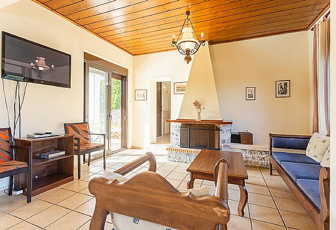 Living room with sofas, dining area, ornamental fireplace, satellite TV, WiFi Internet, DVD player, and terrace access . - Ekklisies Dio . (Galerie de photos) }}