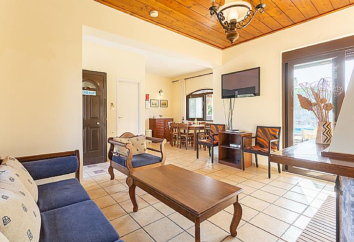 Living room with sofas, dining area, ornamental fireplace, satellite TV, WiFi Internet, DVD player, and terrace access . - Ekklisies Dio . (Fotogalerie) }}