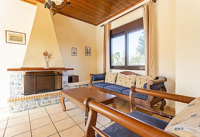 Living room with sofas, dining area, ornamental fireplace, satellite TV, WiFi Internet, DVD player, and terrace access . - Ekklisies Dio . (Fotogalerie) }}