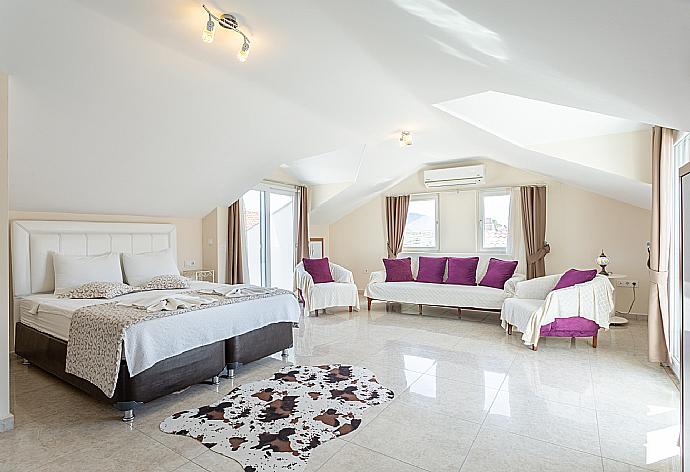 Double bedroom with en suite bathroom, A/C, seating area, and balcony access . - Villa Seda . (Photo Gallery) }}