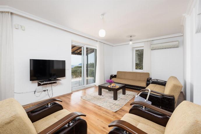 Open-plan living room with sofas, dining area, kitchen, A/C, WiFi internet, satellite TV, and sea views . - Villa Erdem . (Photo Gallery) }}