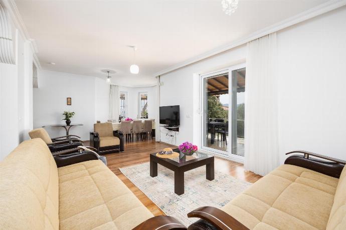 Open-plan living room with sofas, dining area, kitchen, A/C, WiFi internet, satellite TV, and sea views . - Villa Erdem . (Photo Gallery) }}