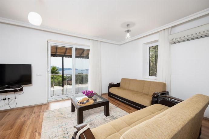 Open-plan living room with sofas, dining area, kitchen, A/C, WiFi internet, satellite TV, and sea views . - Villa Erdem . (Photo Gallery) }}