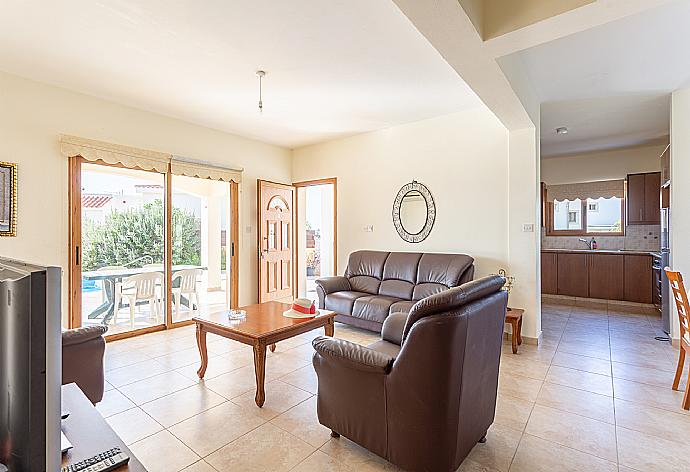 Open-plan living room with sofas, dining area, kitchen, A/C, WiFi internet, satellite TV, and terrace access . - Hector Beach Villa . (Galleria fotografica) }}