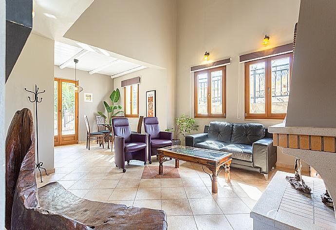 Open-plan living room with sofas, dining area, kitchen, ornamental fireplace, WiFi internet, satellite TV, DVD player, and terrace access  . - Villa Stratos . (Fotogalerie) }}