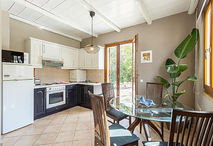 Open-plan living room with sofas, dining area, equipped kitchen, ornamental fireplace, WiFi internet, satellite TV, DVD player, and terrace access  . - Villa Stratos . (Galleria fotografica) }}