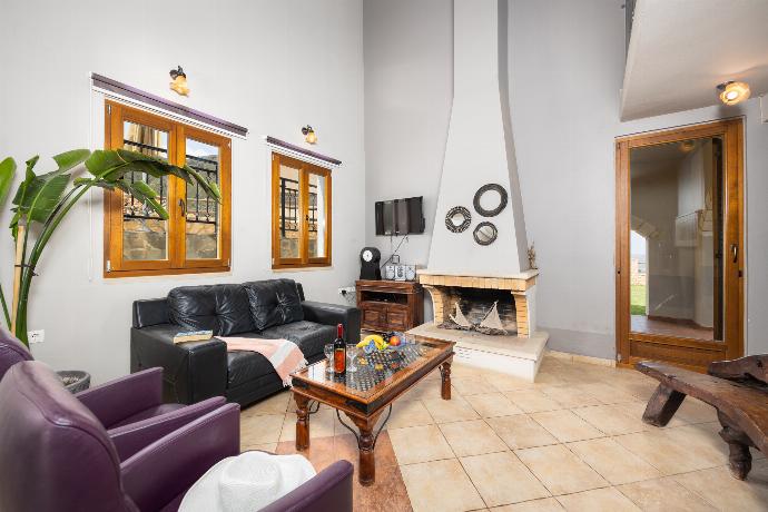 Open-plan living room with sofa, dining area, kitchen, ornamental fireplace, WiFi internet, and satellite TV . - Villa Stratos . (Galerie de photos) }}