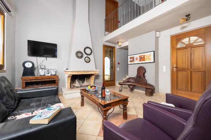 Open-plan living room with sofa, dining area, kitchen, ornamental fireplace, WiFi internet, and satellite TV . - Villa Stratos . (Galerie de photos) }}