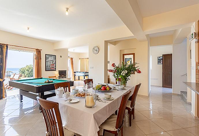 Open-plan living room with sofas, dining area, kitchen, ornamental fireplace, A/C, WiFi internet, satellite TV, pool table, foosball table, and terrace access with sea views . - Kalisto Beach Villa . (Galleria fotografica) }}