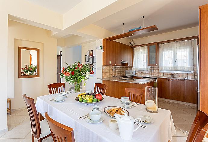 Open-plan living room with sofas, dining area, kitchen, ornamental fireplace, A/C, WiFi internet, satellite TV, pool table, foosball table, and terrace access with sea views . - Kalisto Beach Villa . (Galleria fotografica) }}