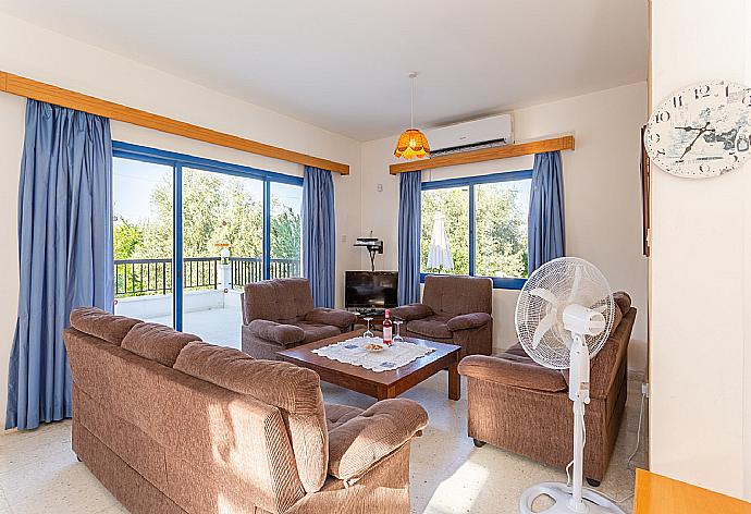 Open-plan living room with sofas, dining area, kitchen, A/C, WiFi internet, satellite TV, and terrace access . - Villa Charoula Thio . (Galería de imágenes) }}