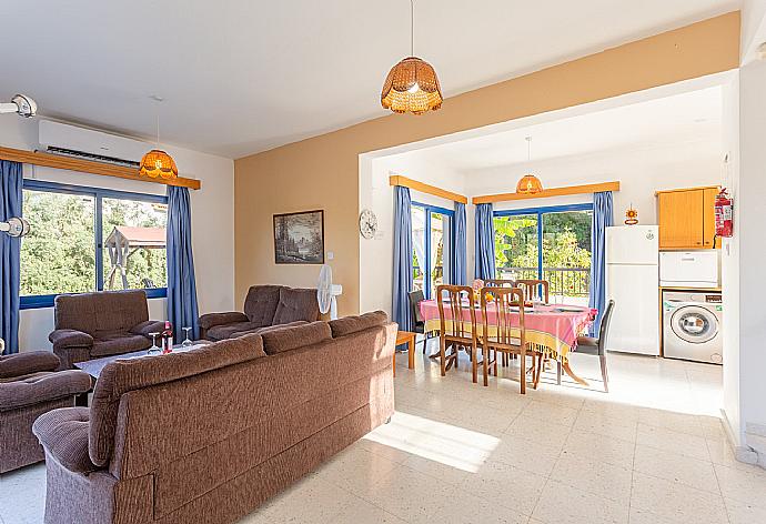 Open-plan living room with sofas, dining area, kitchen, A/C, WiFi internet, satellite TV, and terrace access . - Villa Charoula Thio . (Photo Gallery) }}