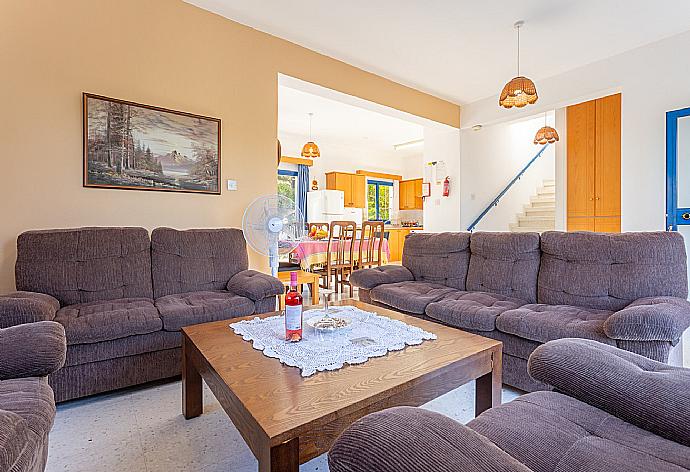 Open-plan living room with sofas, dining area, kitchen, A/C, WiFi internet, satellite TV, and terrace access . - Villa Charoula Thio . (Galería de imágenes) }}