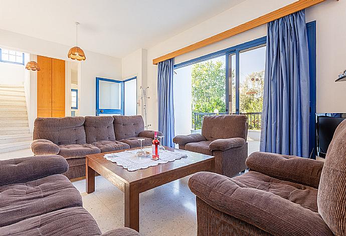 Open-plan living room with sofas, dining area, kitchen, A/C, WiFi internet, satellite TV, and terrace access . - Villa Charoula Thio . (Galería de imágenes) }}