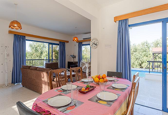 Open-plan living room with sofas, dining area, kitchen, A/C, WiFi internet, satellite TV, and terrace access . - Villa Charoula Thio . (Galería de imágenes) }}