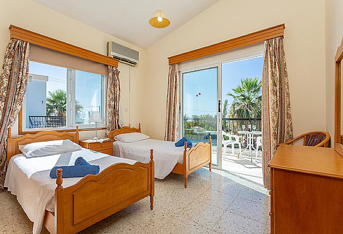 Twin bedroom with en suite bathroom, A/C, and balcony access with sea views . - Argaka Sun Villa Thio . (Photo Gallery) }}