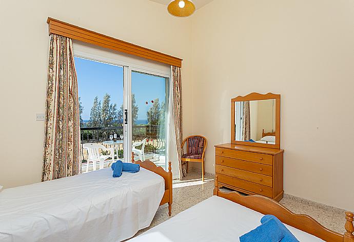 Twin bedroom with en suite bathroom, A/C, and balcony access with sea views . - Argaka Sun Villa Thio . (Photo Gallery) }}